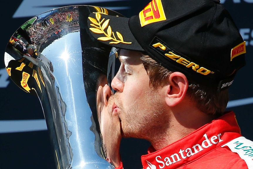 Winner Ferrari Formula One driver Sebastian Vettel of Germany kisses the trophy after the Hungarian F1 Grand Prix