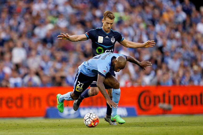 Sydney FC and Melbourne Victory challenge for the ball