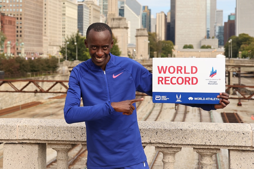 Kelvin Kiptum holds a plaque that says World Record