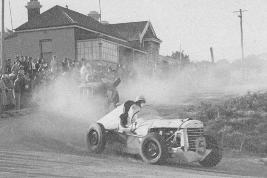 Cars racing in historic image