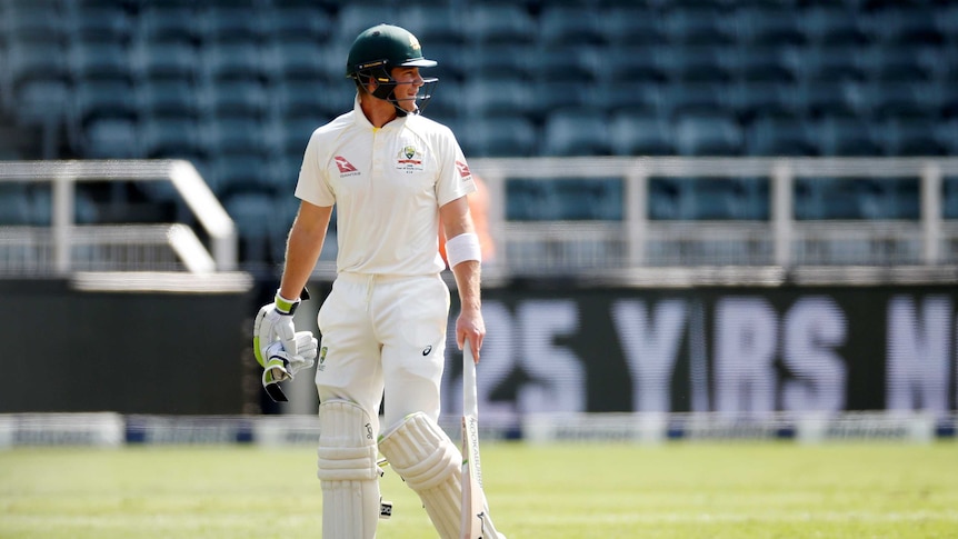 Tim Paine looks behind himself as he drags his bat while walking off the field.