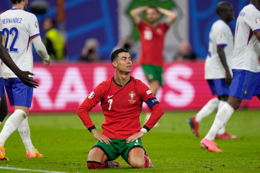 Cristiano Ronaldo kneels on the ground