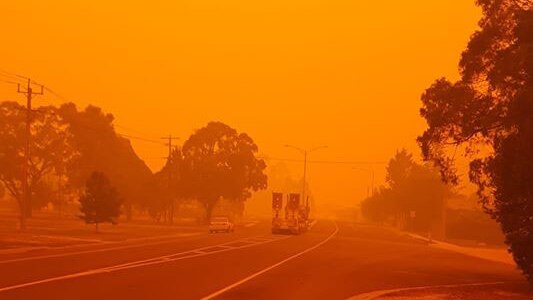 Cann River is bathed in an orange glow with a fire truck in the distance.