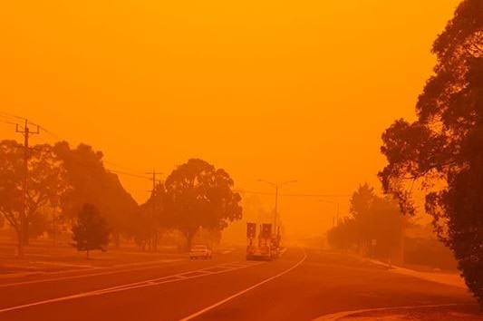 Cann River is bathed in an orange glow with a fire truck in the distance.