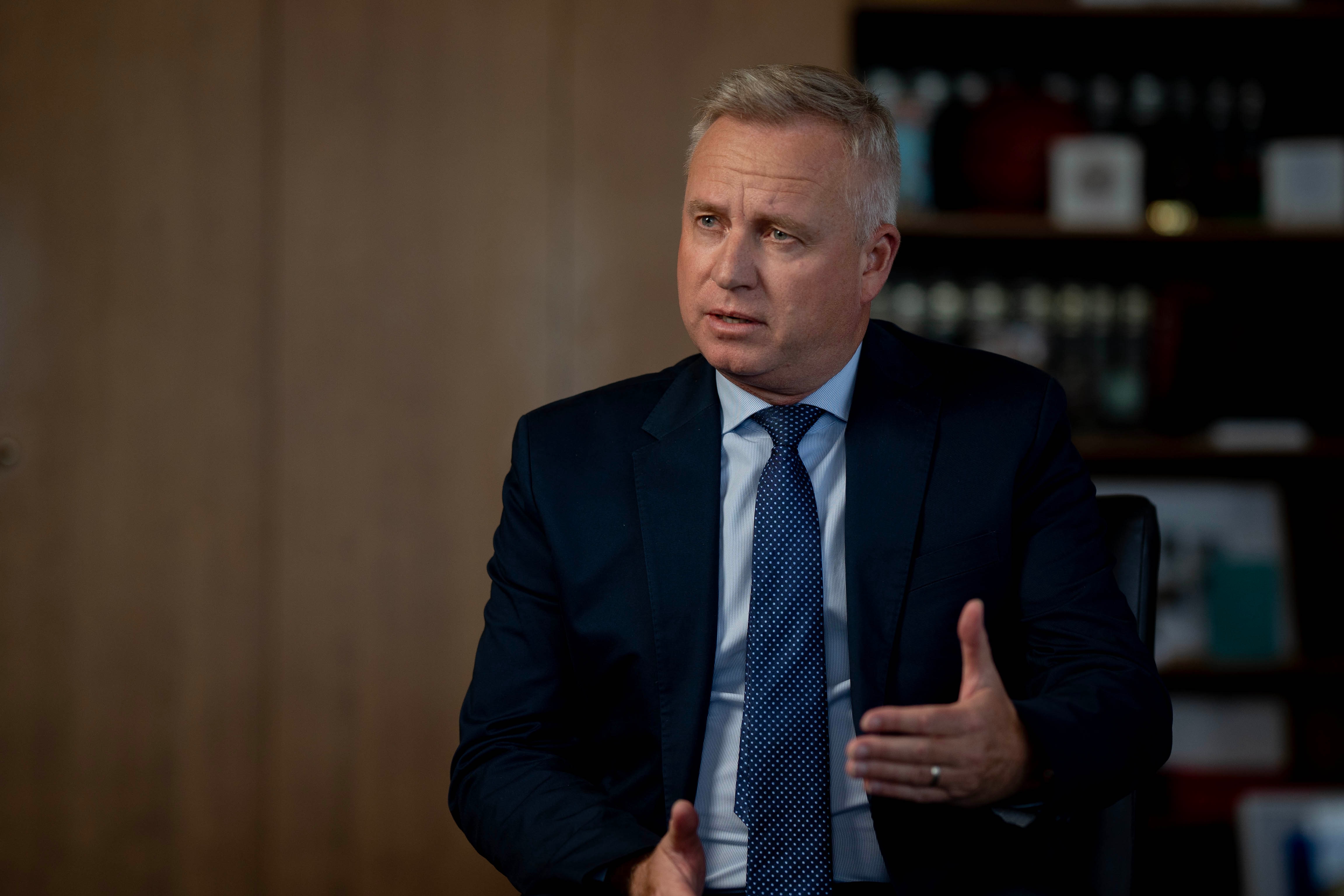 A male politician sits in a suit during an interview.
