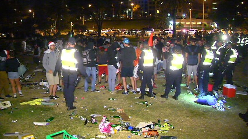 Police work to move hundreds of people off the St Kilda foreshore.