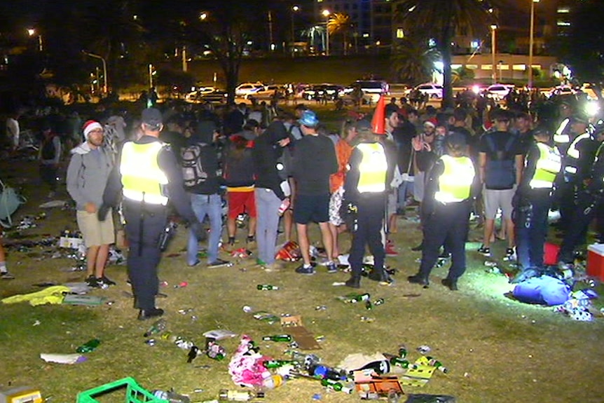 Police work to move hundreds of people off the St Kilda foreshore.