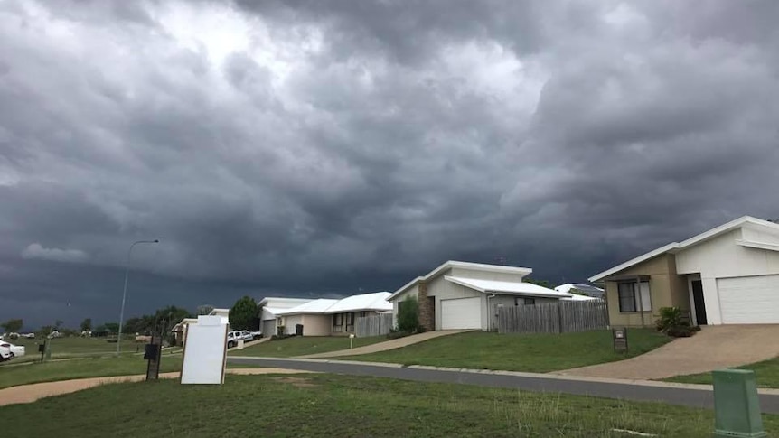 A photo of new houses in a street in Gracemere, with dark clouds in the sky.