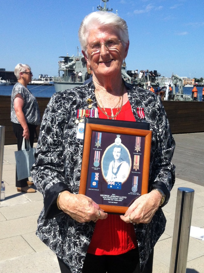 Pat Sibley holding a photo of her father George Lloyd who died on HMAS Yarra