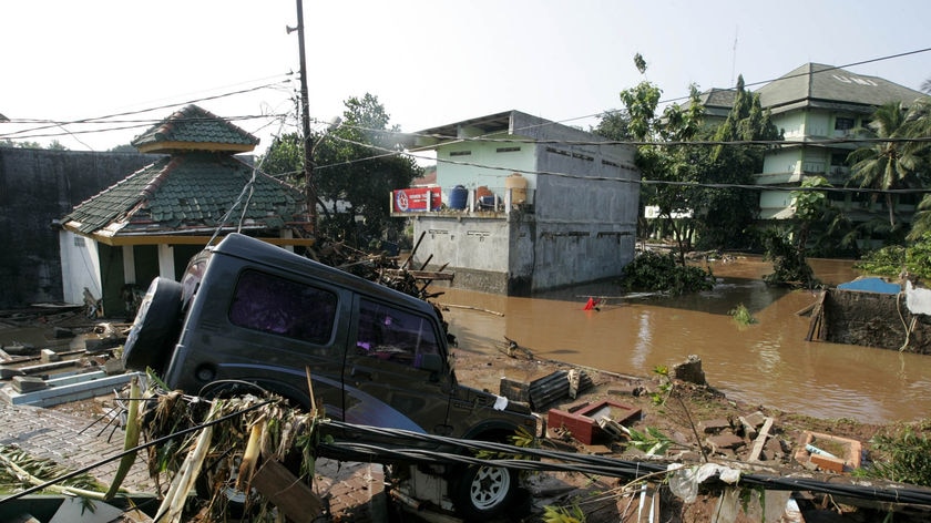 A car is perched on debris after the flood in Jakarta on March 27, 2009.