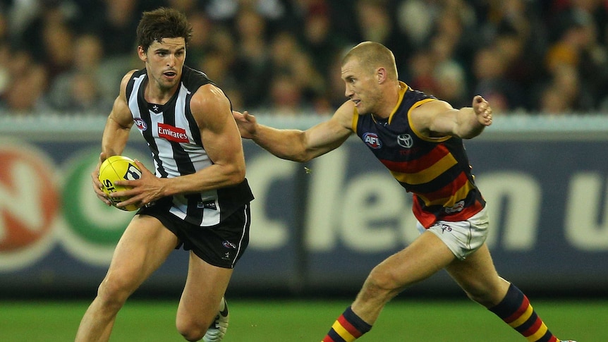 The Magpies' Scott Pendlebury runs with the ball away from Adelaide's Scott Thompson.