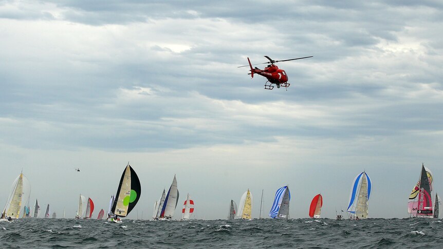 A media helicopter chases the Sydney to Hobart fleet at it leaves Sydney Harbour.