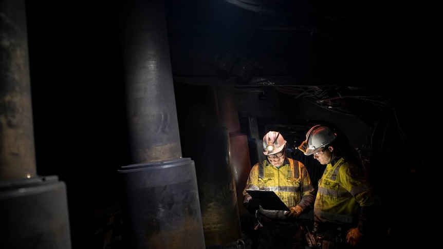 Men work inside an underground coal mine.