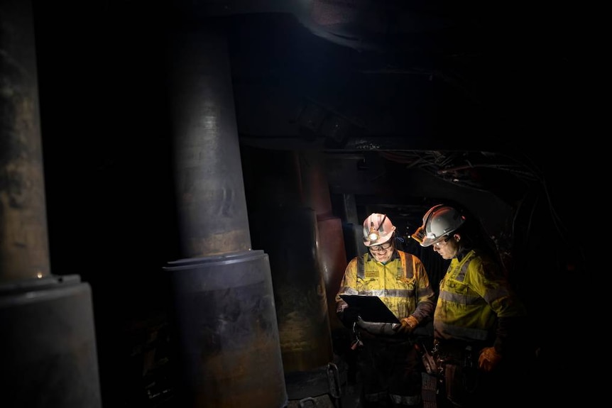 Men work inside an underground coal mine.