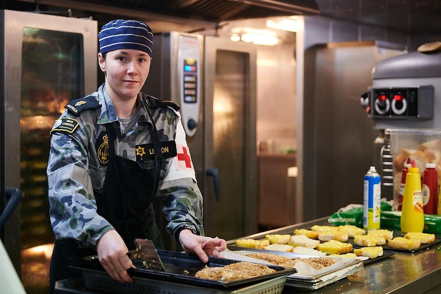 advertising campaign from Defence Force Aus, young chef in camo gear baking in navy kitchen.