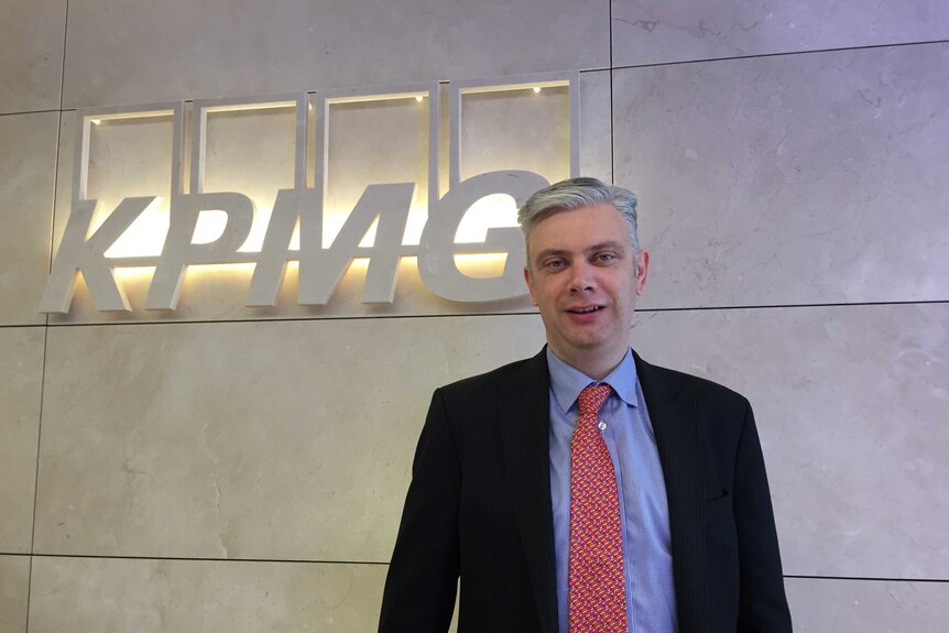 sign for KPMG and a man in suit and tie