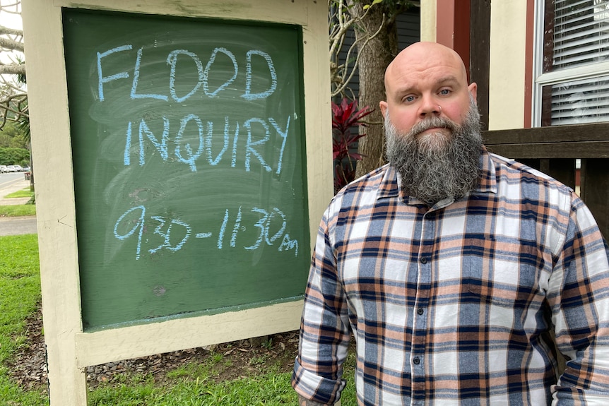 Man stands in front of a chalk-drawn sign