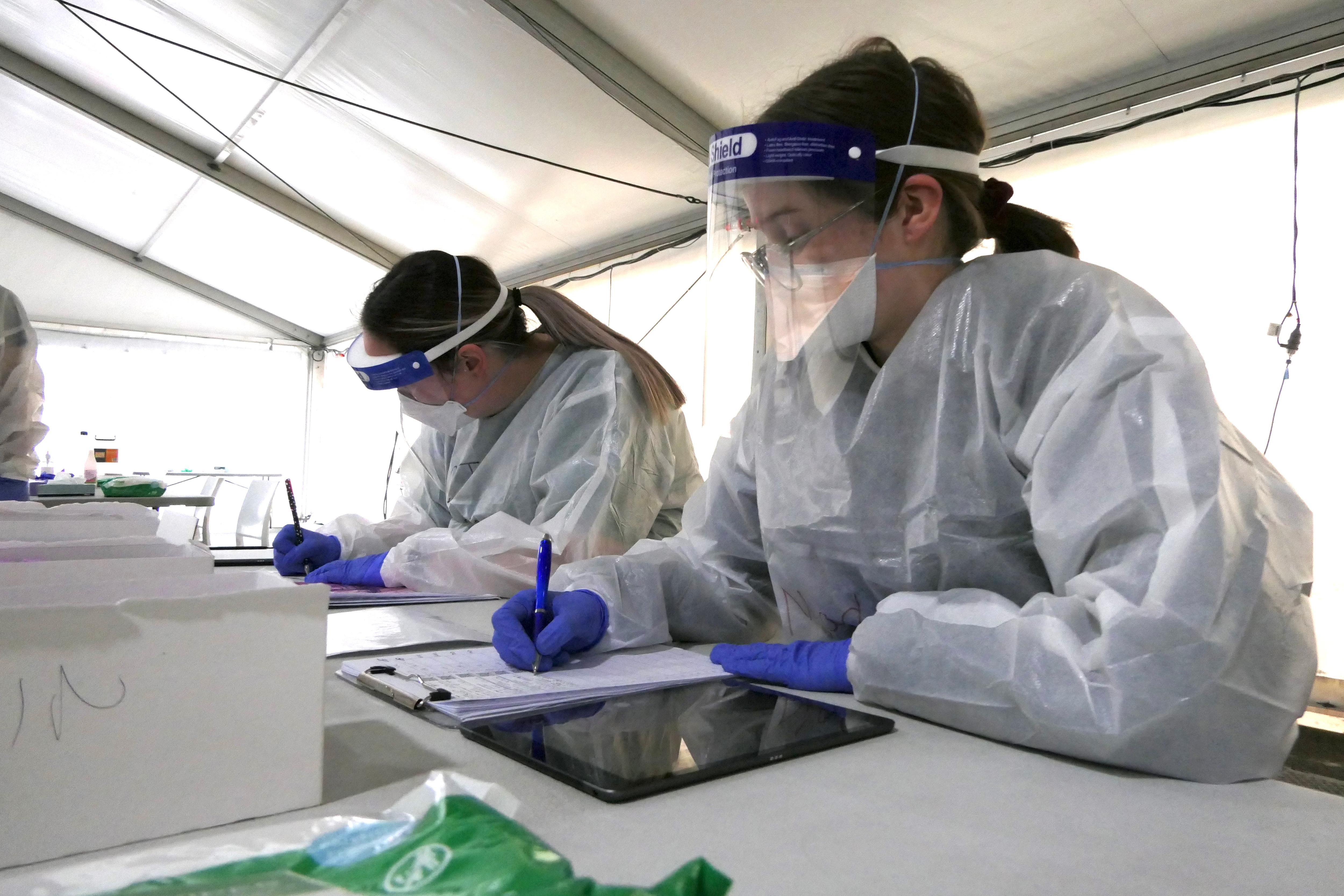 Two health workers in protective gear.