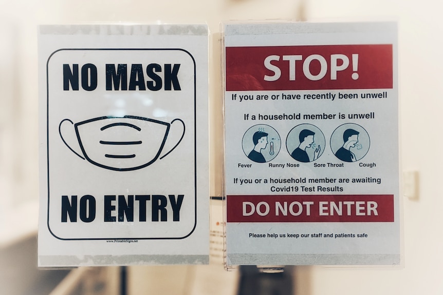 A sign warning people to wear masks and not to enter if they are feeling unwell.