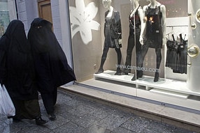 Women wearing burkas walk past clothing stores in France. (Jean-Paul Pelissier/Reuters)