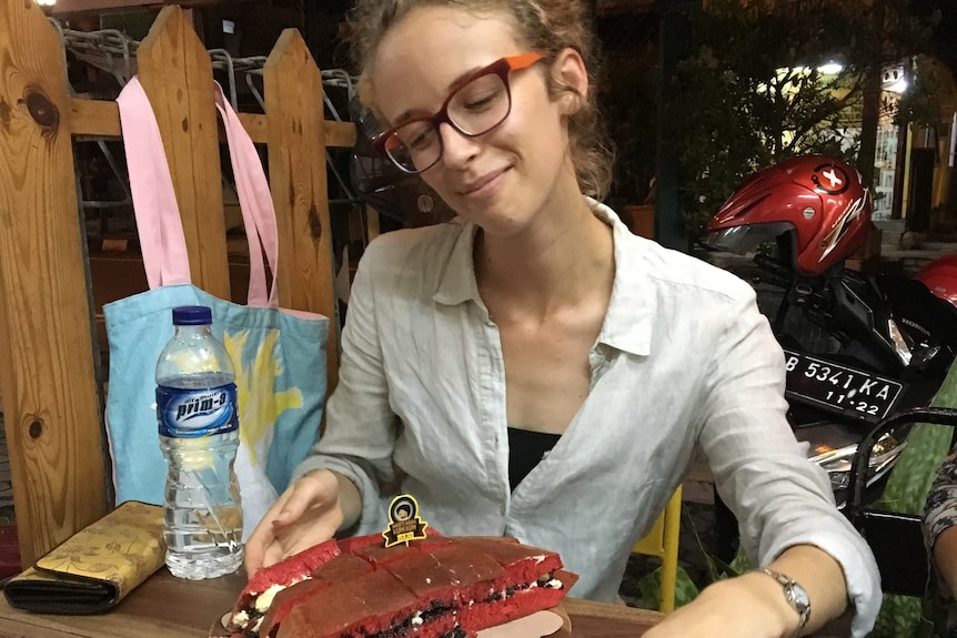 A woman looks at a plate of food.