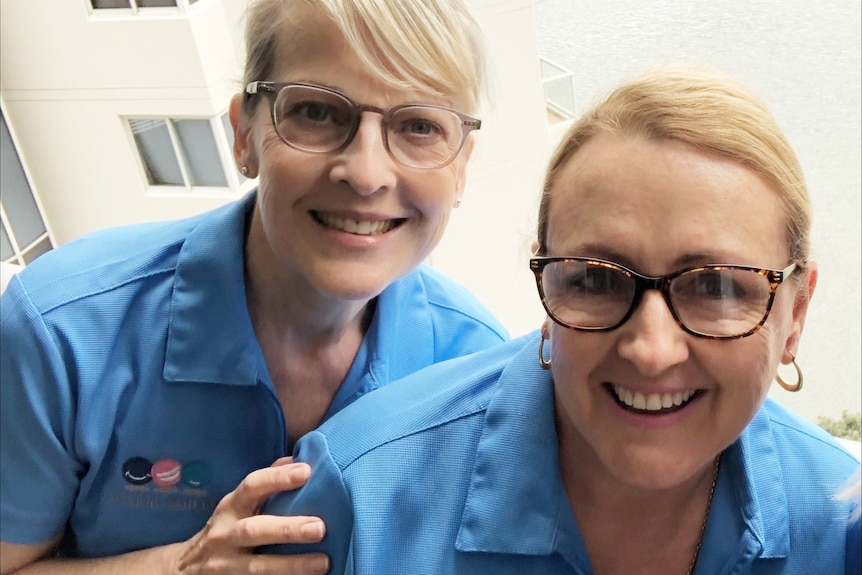 Two women in blue uniforms