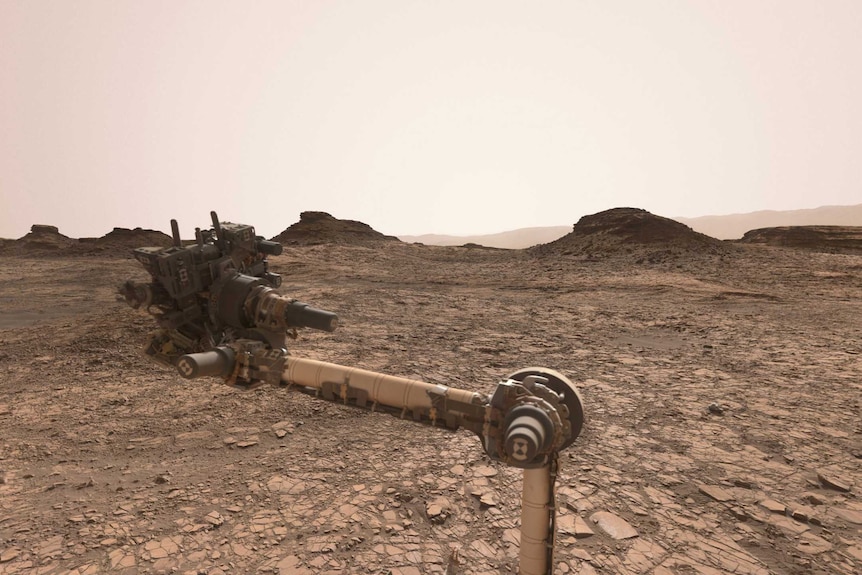 Several mounds of rocks sit on the dry Martian landscape.