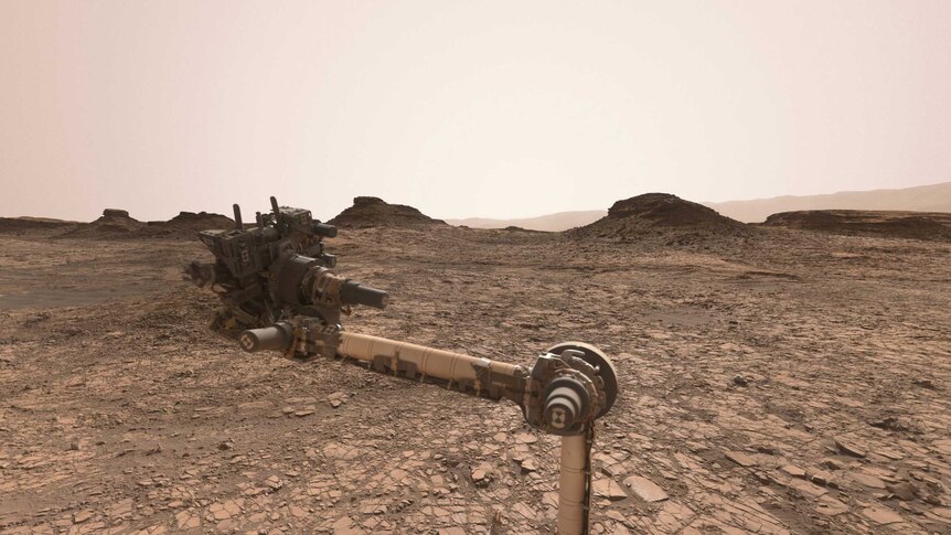 Several mounds of rocks sit on the dry Martian landscape.