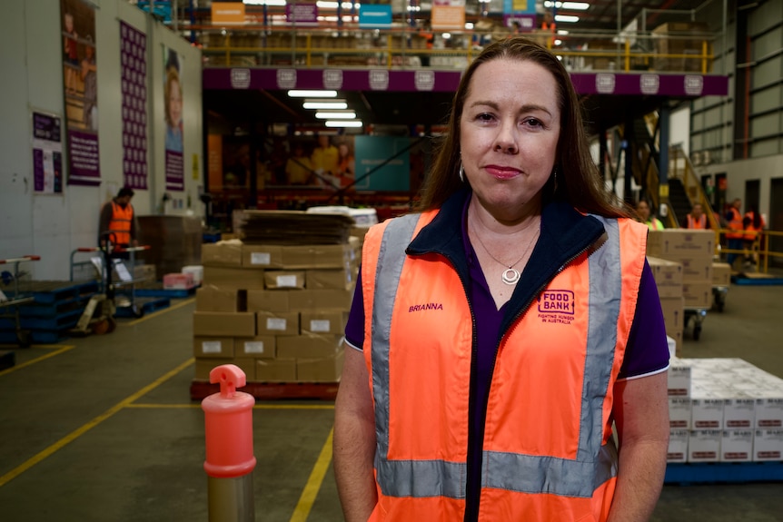A woman in a hi-vis vest at a food warehouse.