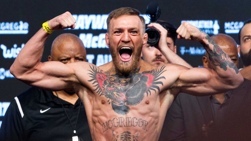 UFC lightweight champion Conor McGregor of Ireland poses on the scale.