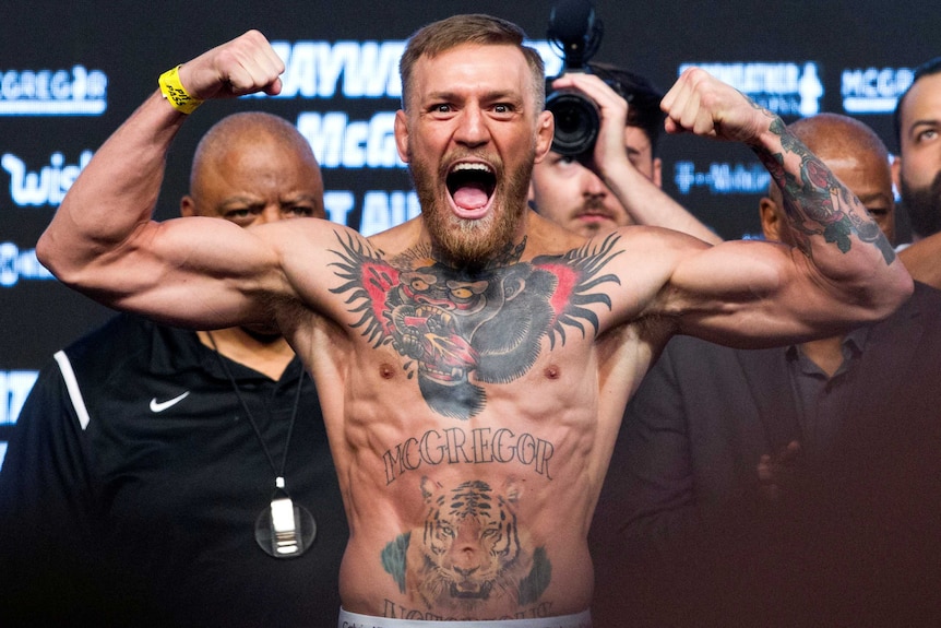 UFC lightweight champion Conor McGregor of Ireland poses on the scale.