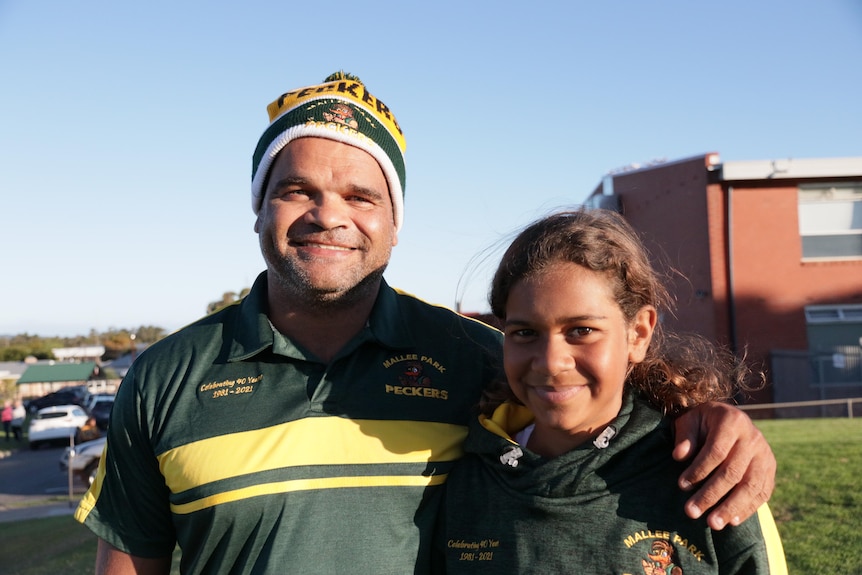 Former Adelaide crows player Graham Johncock and his daughter smiling.