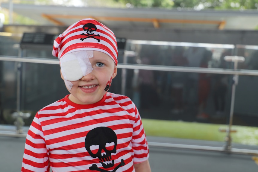 Alice wearing a red and white striped pirate hat and shirt, medical eye patch covering her eye.