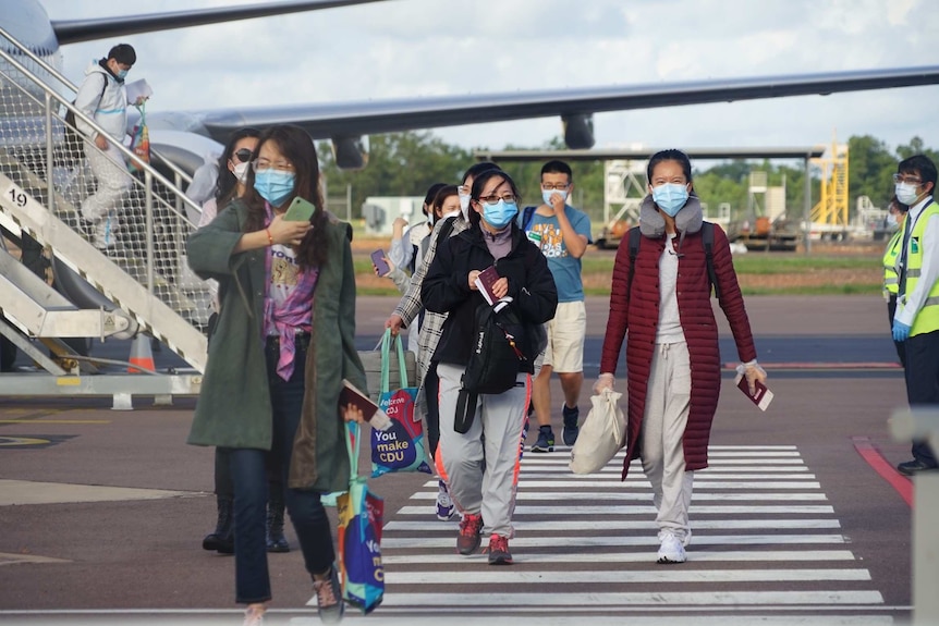 International students walk along the tarmac at Darwin Airport.