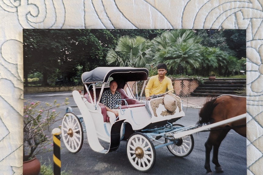 A man sits in a horse-drawn carriage.