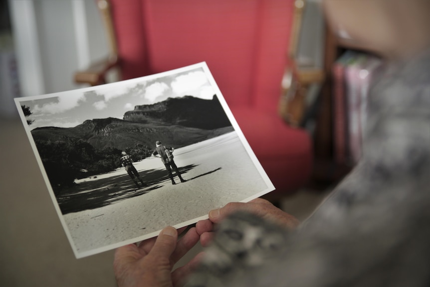 A pair of hands holding an old photo.