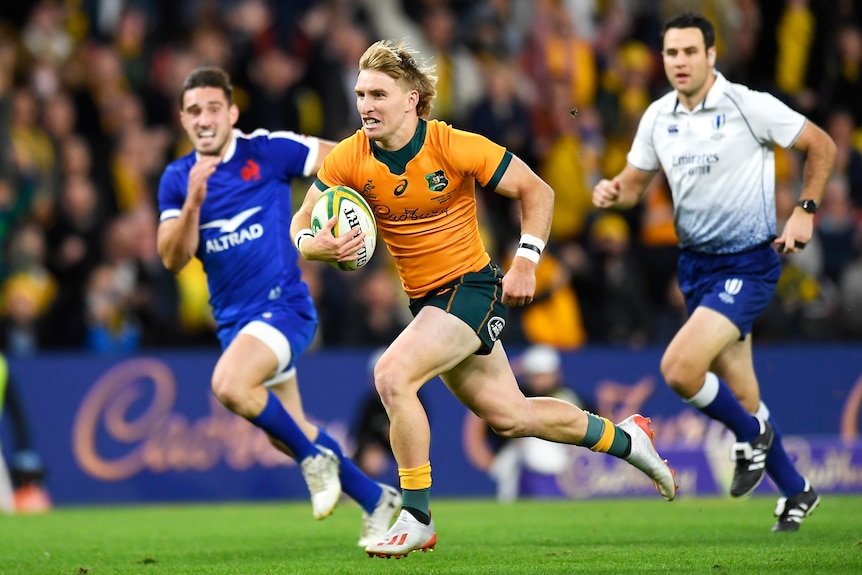 A Wallabies player runs with the ball against France.