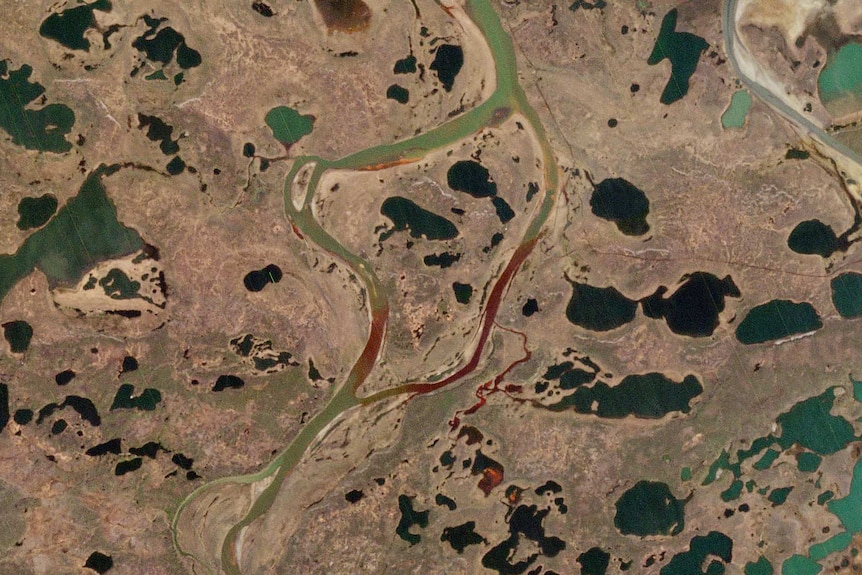 A satellite image showing the extent of the spill. The river system is partially red due to the spill, it is normally green.