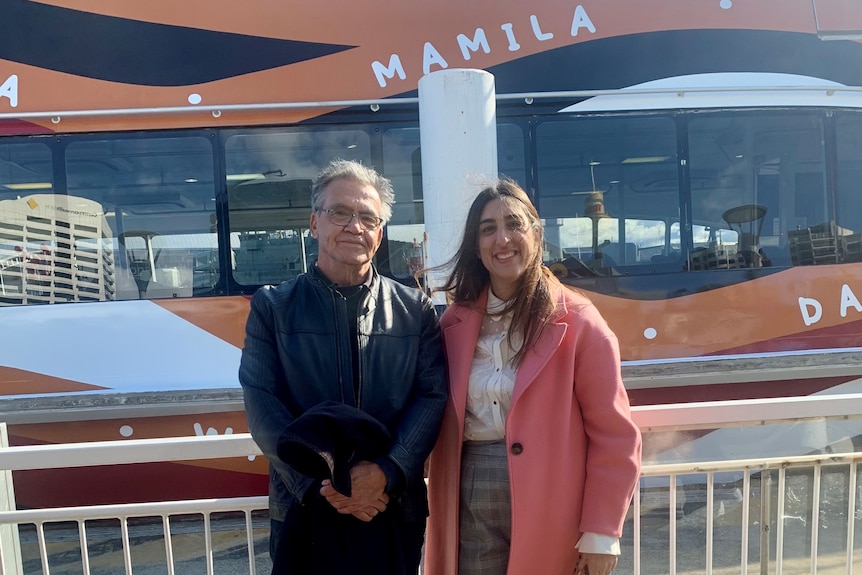 Warwick Keen and Marie Ferrett stand in front of the new Sydney cruise ferry featuring his distinctive wrap design