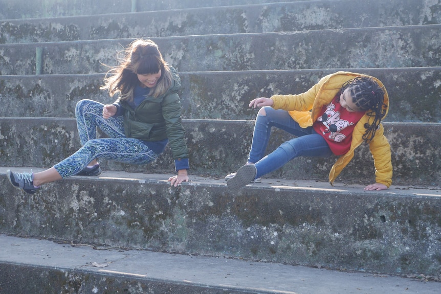 Ейми Хан обучава по-младо момиче да прави паркур на някои бетонни стъпала