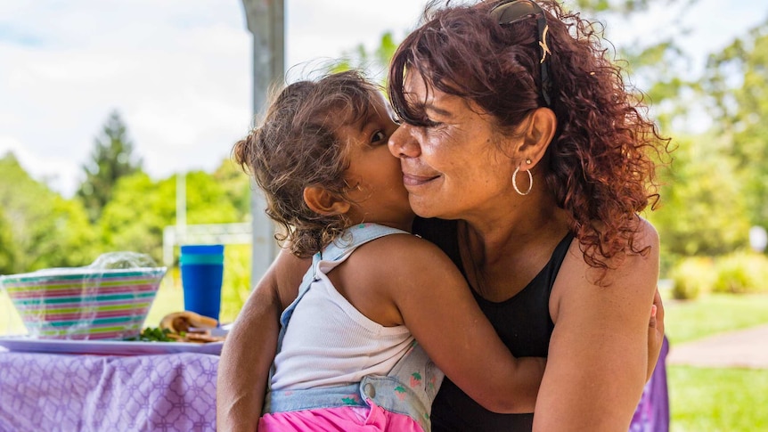 Australian Aboriginal woman hugging her grandchild