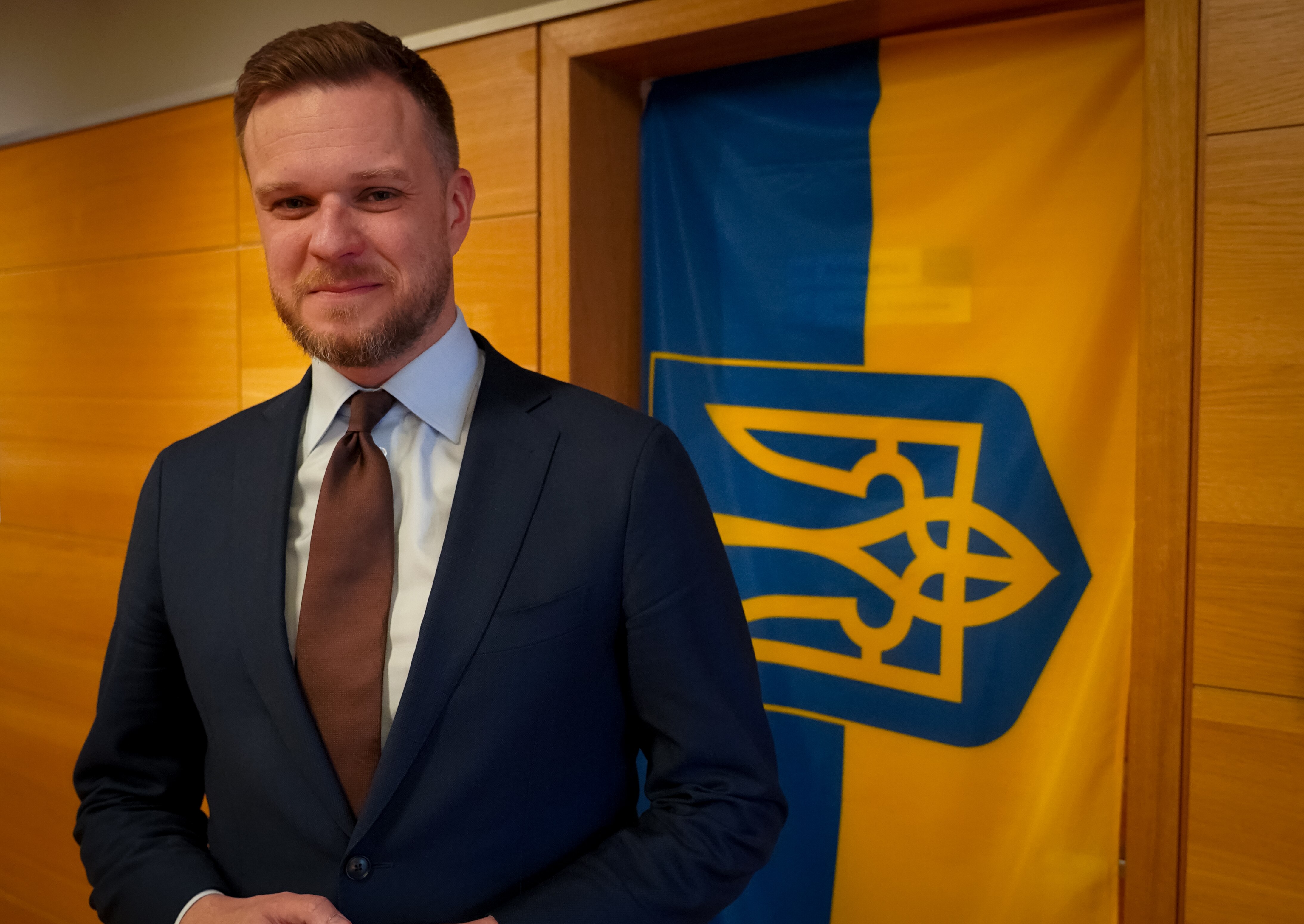 A man in a suit smiles