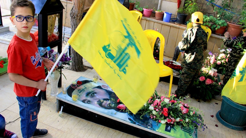 Little boy at the grave of a Hezbollah fighter killed in Syria.