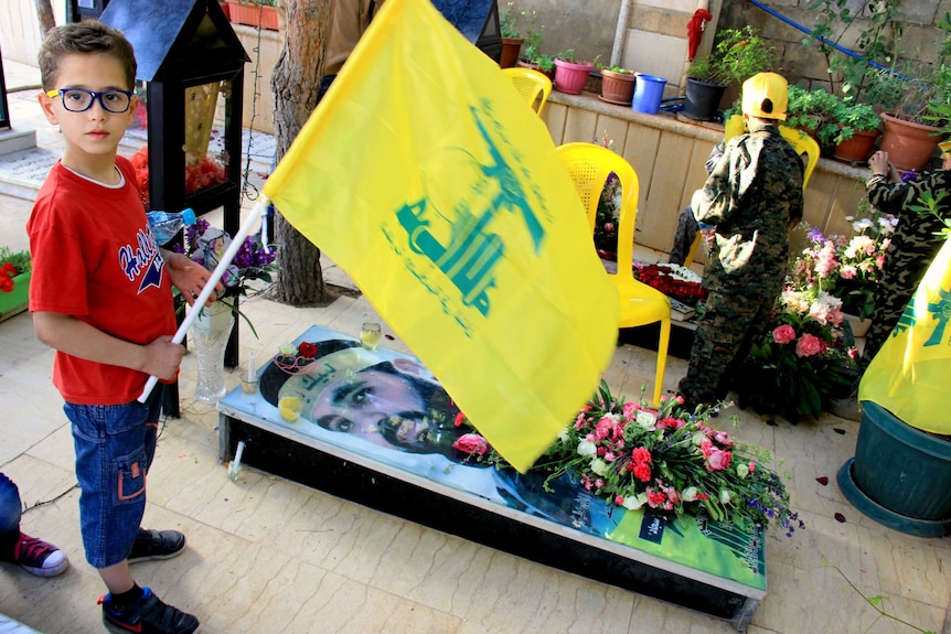 Little boy at the grave of a Hezbollah fighter killed in Syria.