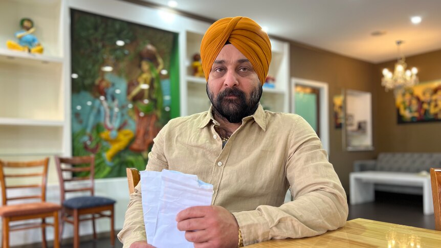 Jarnail Singh holding pieces of paper.