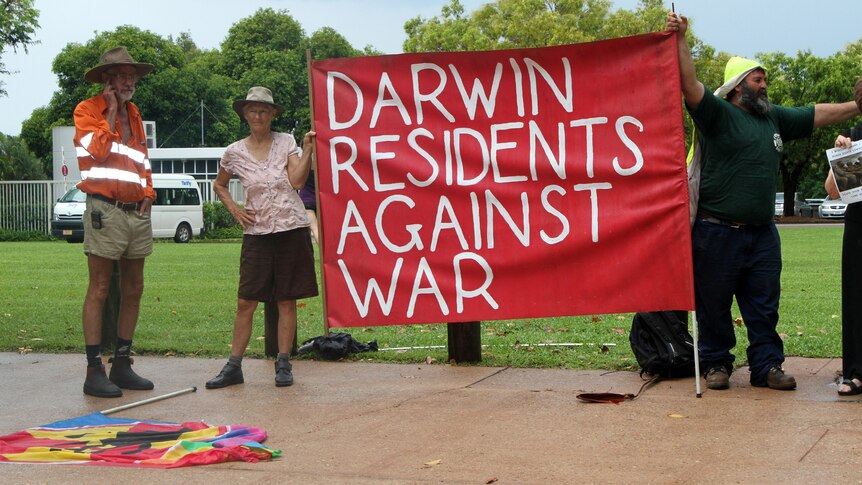 Demonstrators gather outside of the NT Parliament House to protest ahead of the visit.