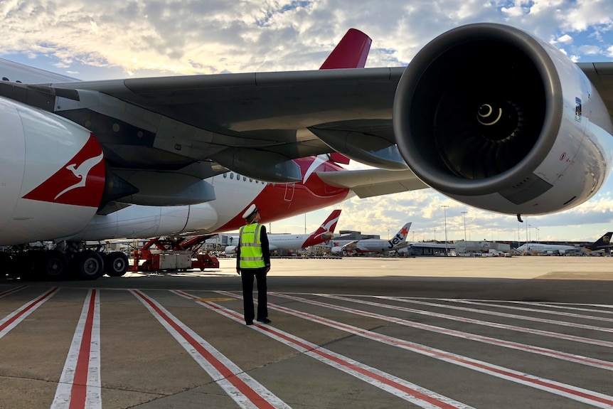 Second officer Arika Maloney inspects the wing of a Qantas plane.