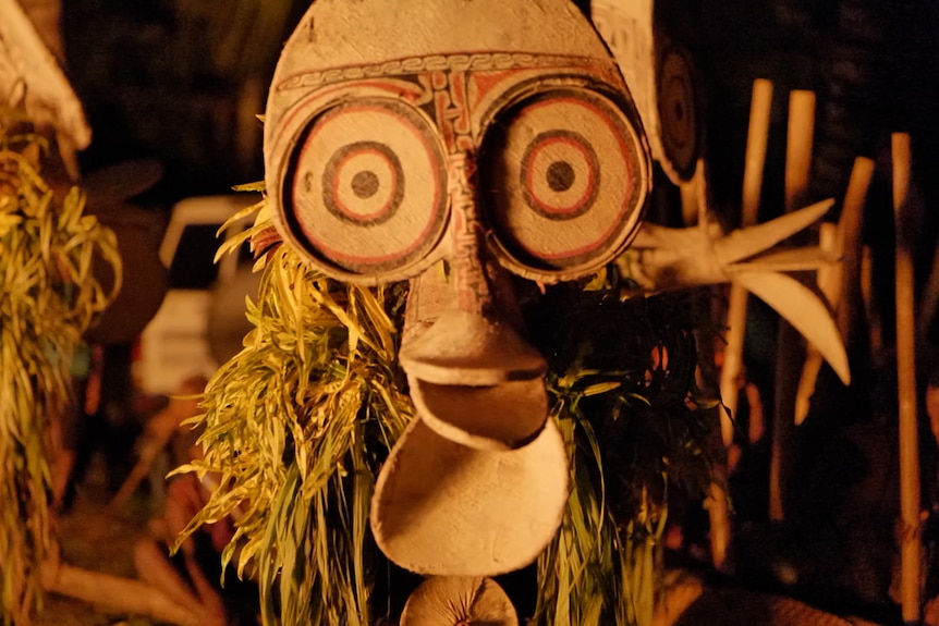 Man dressed in oversized costume made of wood and grasses. 