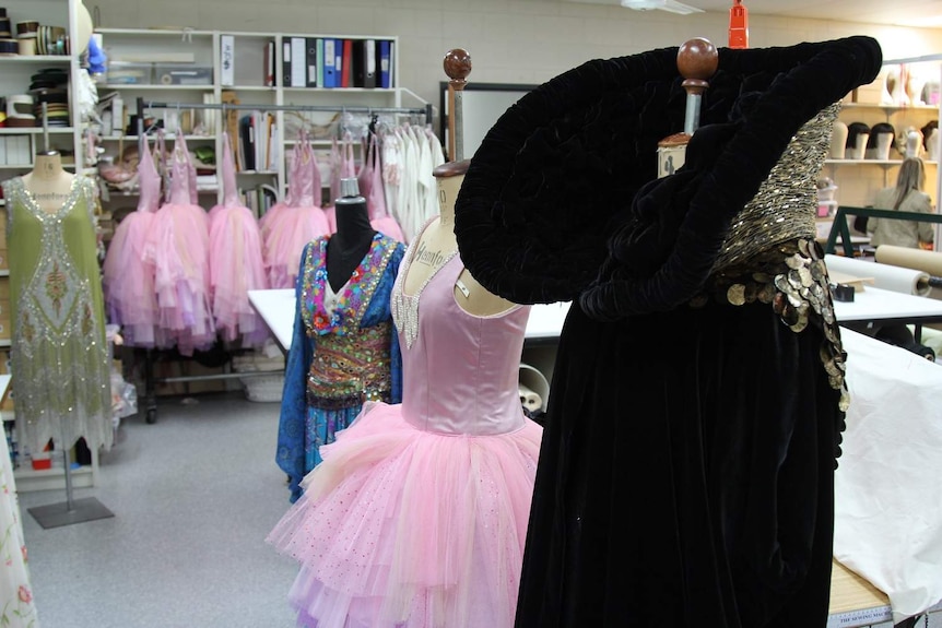 Room full of dresses and costumes hanging on racks