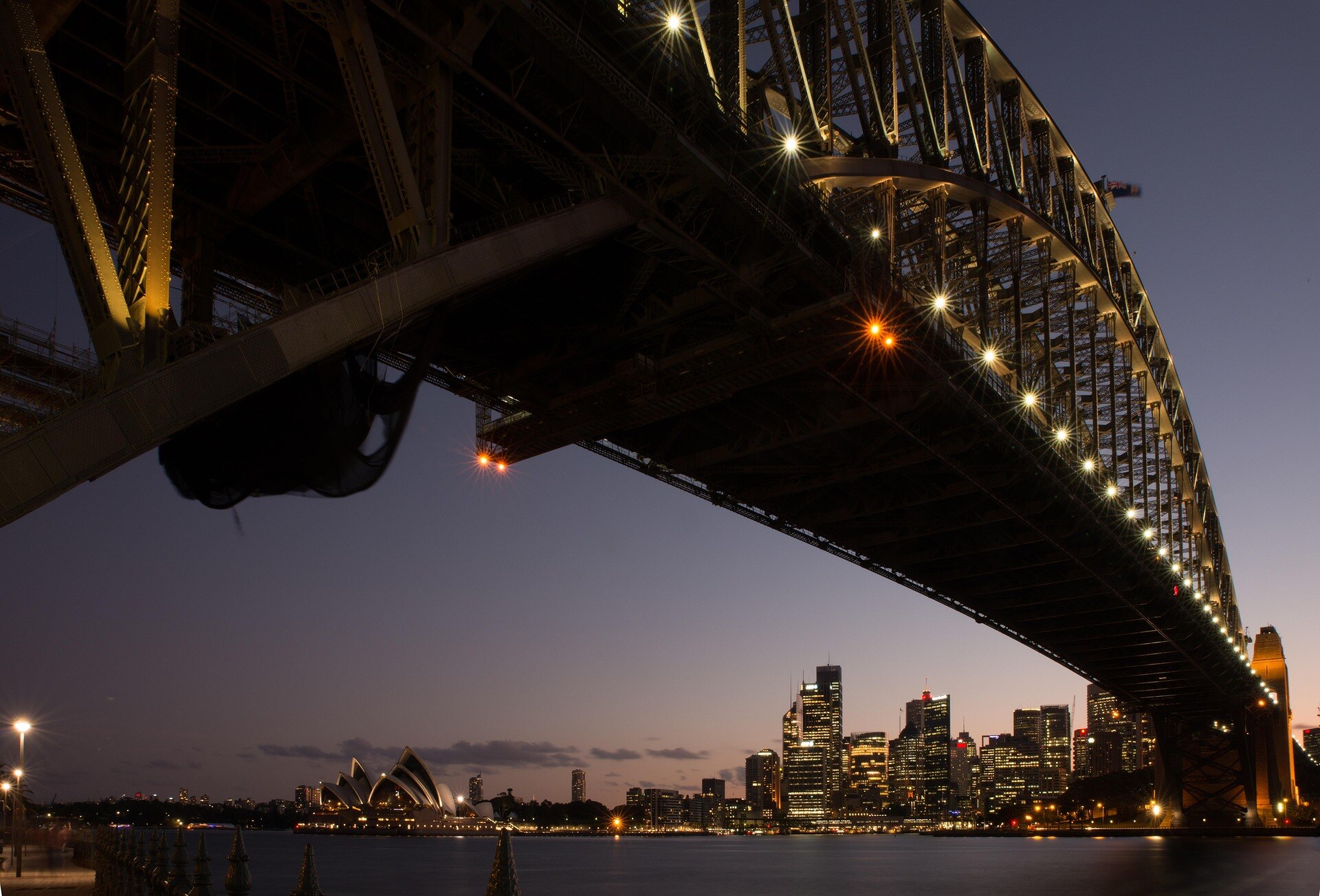 Sydney Harbour Bridge at dusk with city skyline and Opera House in the background